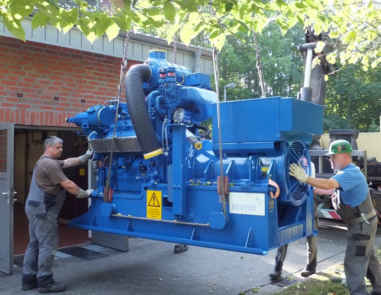 Der Gasmotor TCG 2016, Herzstück des BHKW in Sellin, wird am Heizhaus des Ostseebades angeliefert.